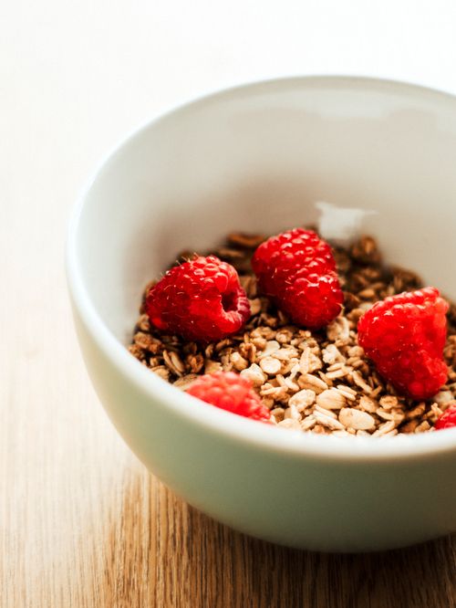 Free Close-up of a white bowl with oats and fresh raspberries, perfect for a healthy breakfast. Stock Photo