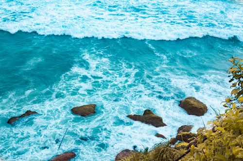 Free High angle view of turquoise ocean waves crashing on rocks. Perfect for travel and nature themes. Stock Photo