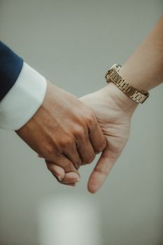 Warm close-up of a couple holding hands, showcasing love and connection.