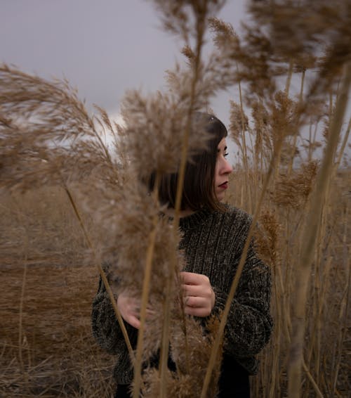 Woman in Black Sweater Standing on Brown Grass Field