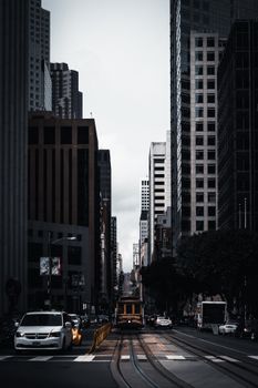 黄昏时分，旧金山的城市街景中，标志性的电车与高耸的摩天大楼交相辉映