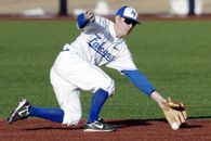 Man Wearing Blue and White Falcons Baseball Jersey Shirt With Brown Baseball Gloves Catching White Baseball