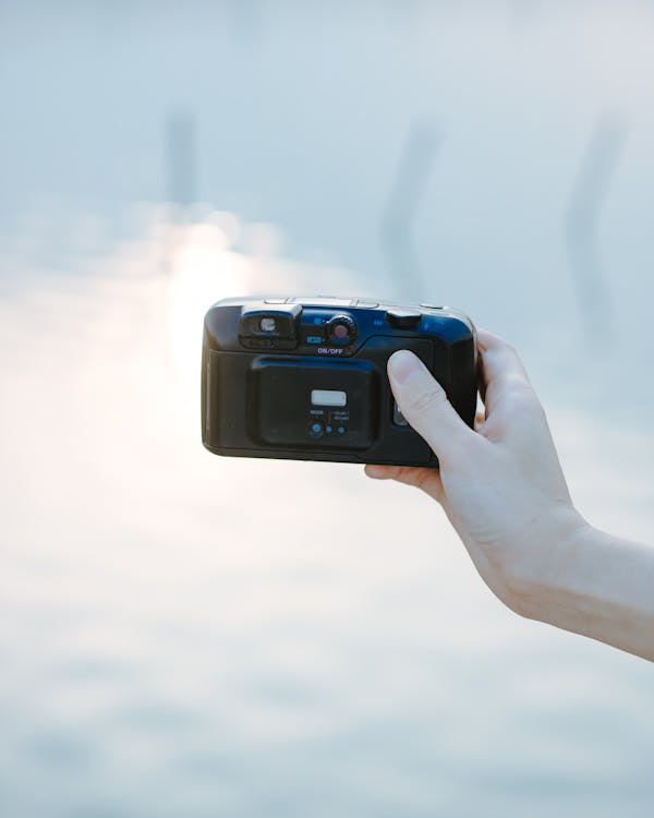 A Person Holding a Black Analog Camera