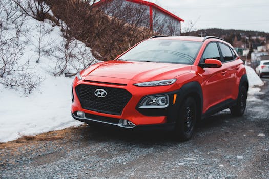 A red Hyundai SUV parked outdoors on a snowy day, showcasing modern design and style.