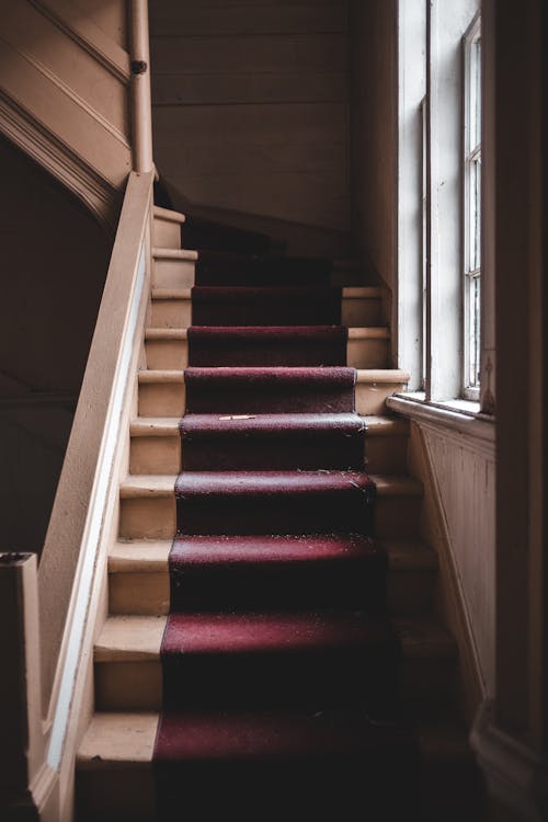 Red and Brown Staircase Near Window