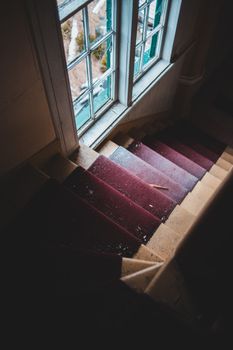 这座废弃建筑的楼梯铺着红地毯，窗户透进自然光，非常适合建筑主题