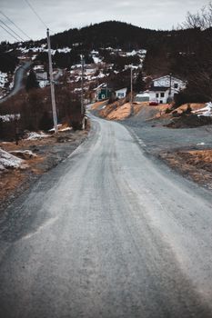 一条孤独的冬季道路蜿蜒穿过白雪皑皑的小村庄