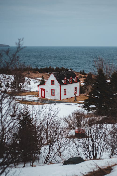 Free White and Red House Near Body of Water Stock Photo
