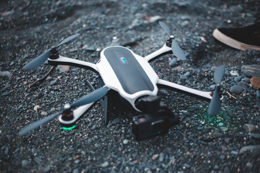 A sleek, modern drone with propellers on a rocky surface, exemplifying advanced technology outdoors.