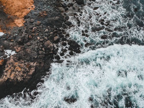 茶色の岩を打つ水の波