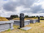 Gray Tomb Stone on Green Grass Field Under Gray Cloudy Sky