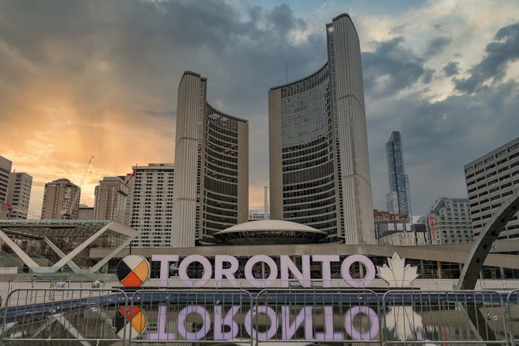 Toronto Signage Near Buildings Under White Clouds