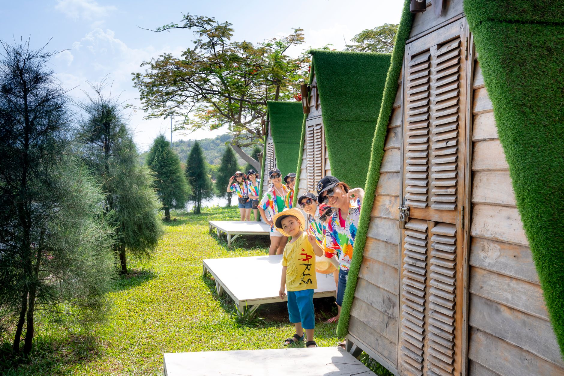 People standing near green nature and houses