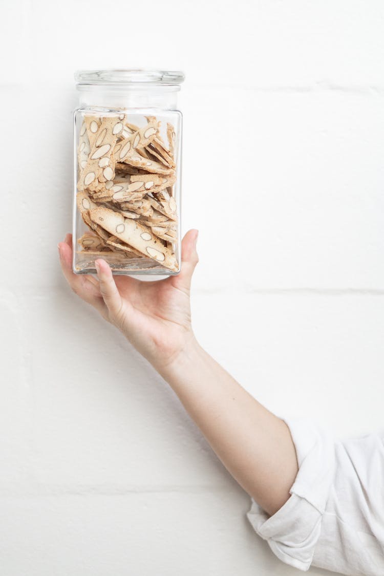 Person Holding Glass Cookie Jar