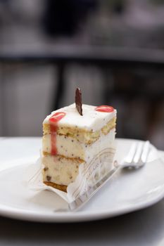 Indulge in a creamy layered cheesecake topped with a chocolate garnish, perfect for dessert lovers.