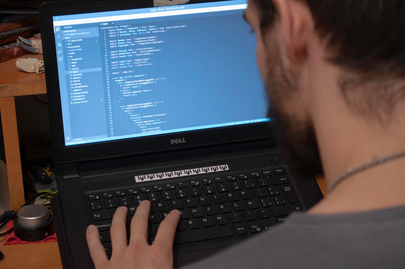 Man working on code with laptop in office environment