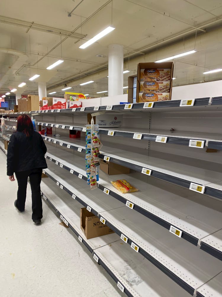 Person Walking On Empty Aisle On Grocery Store