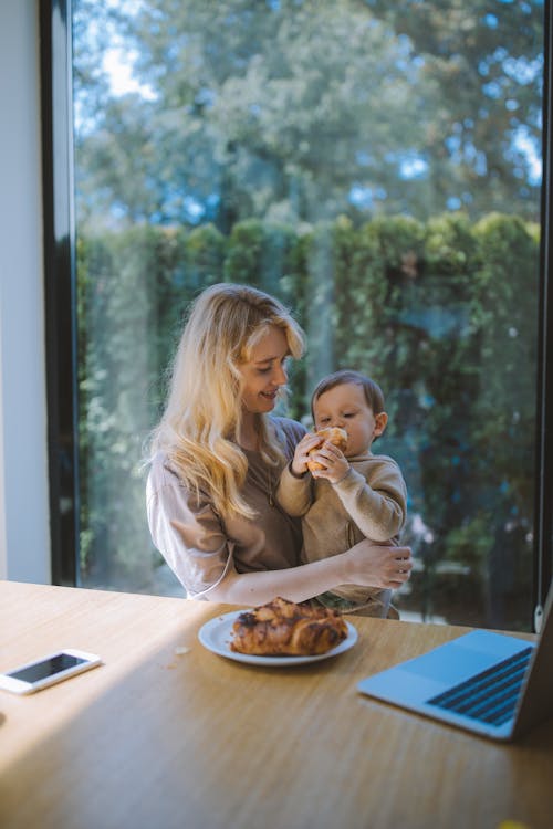 Free Woman Having Breakfast With her Baby Stock Photo