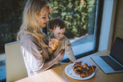Woman Having Breakfast With her Baby