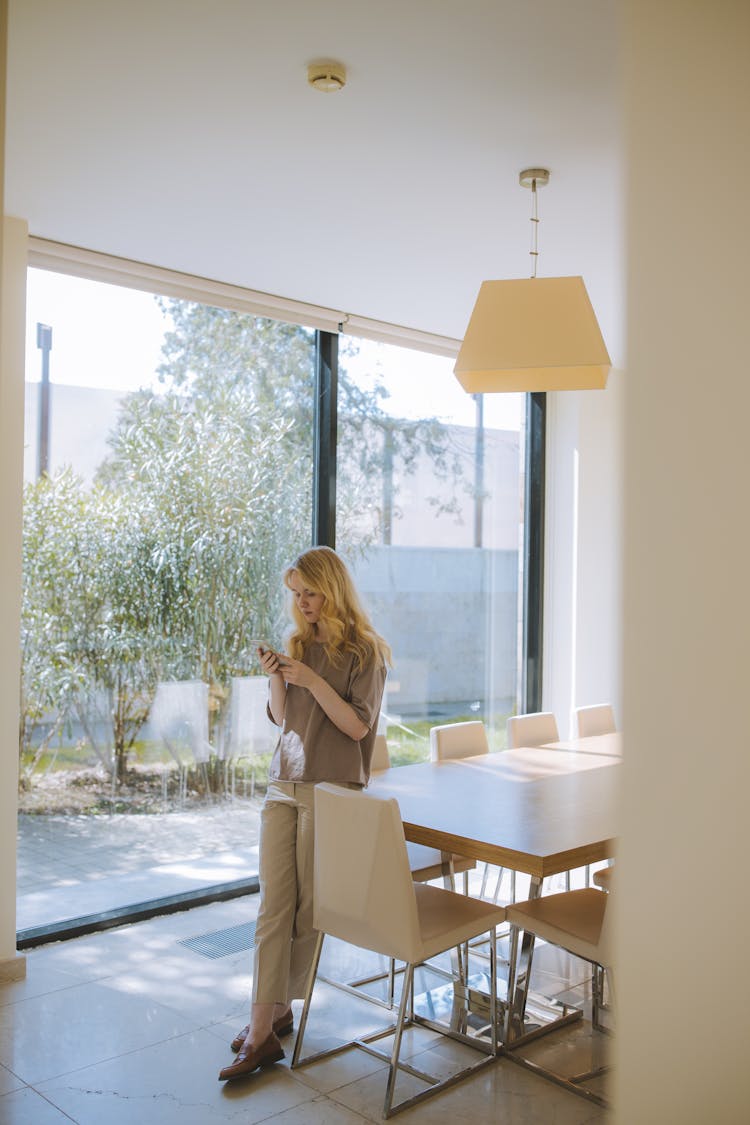 Woman Leaning Against A Table And Texting