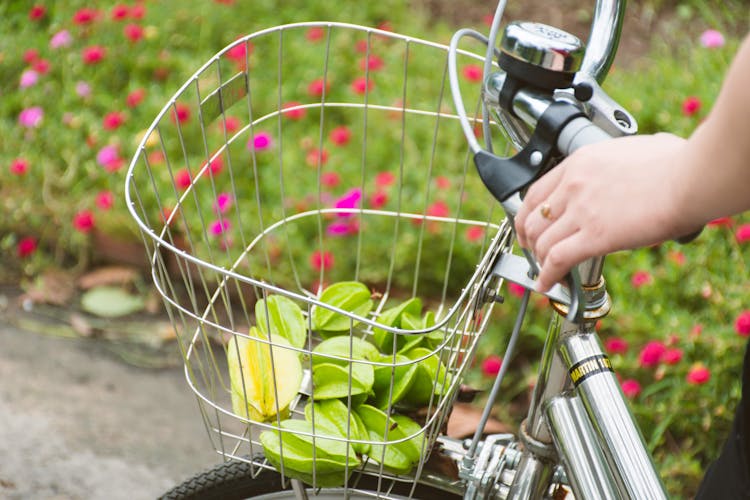 Crop Woman Riding Bicycle On Road In Field