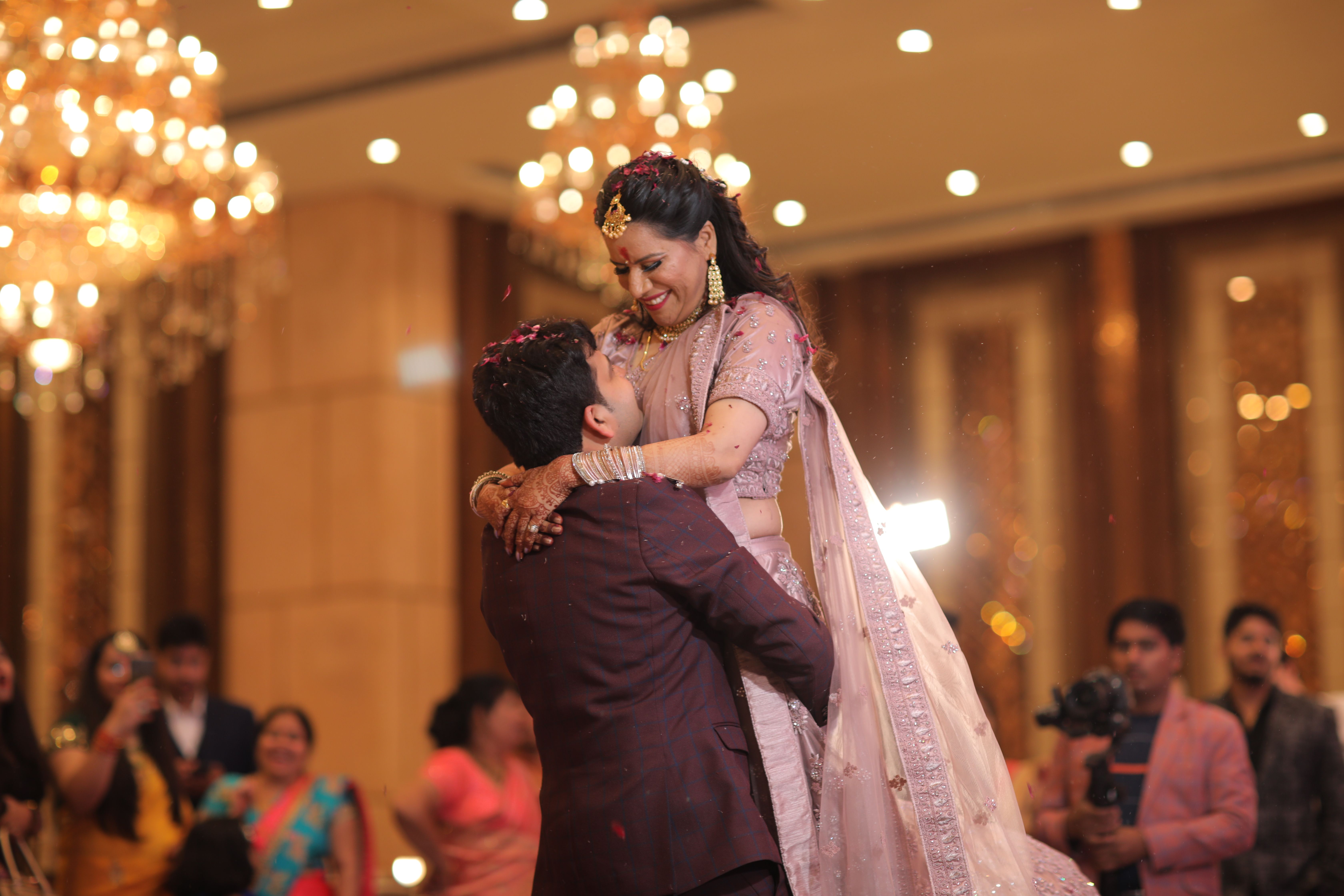 Happy couple embraces in a vibrant indoor wedding ceremony.