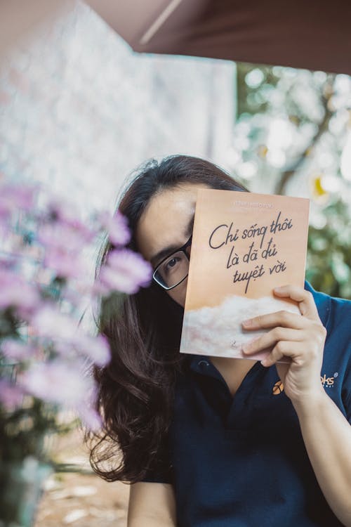 Woman in Black Framed Eyeglasses Holding Card