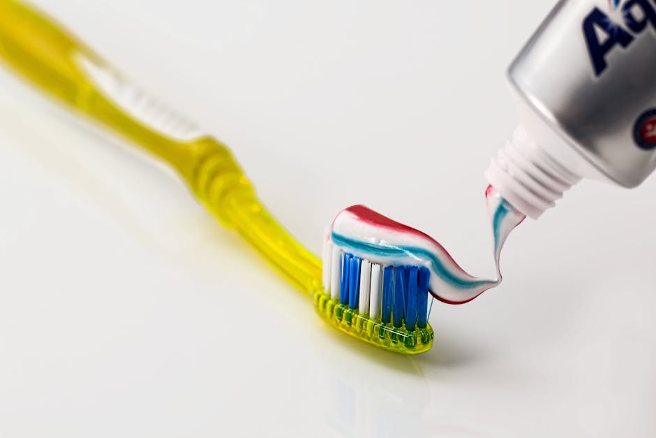 Toothpaste Being Put on Yellow Toothbrush