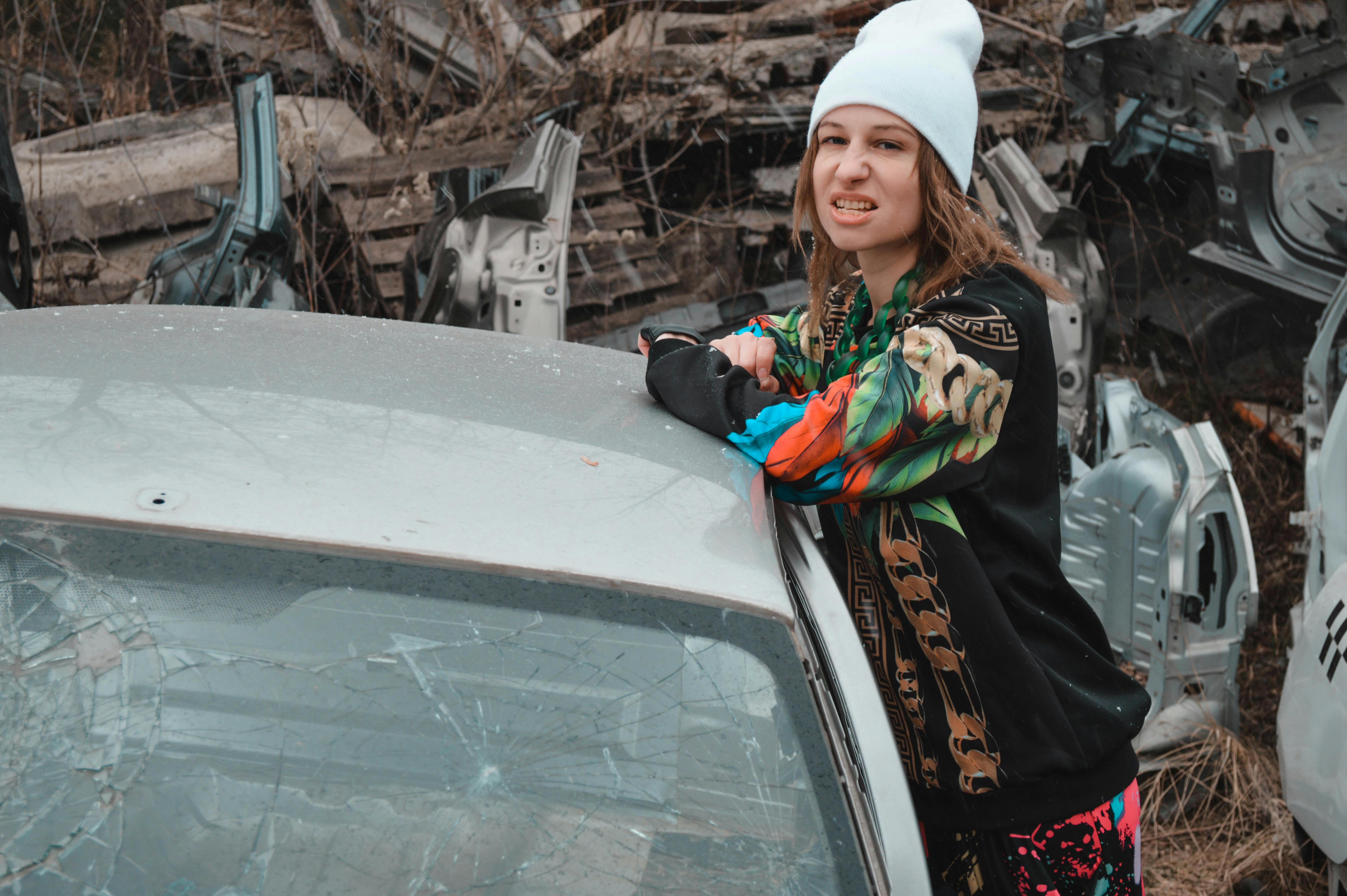 Download A Woman In A Black Jacket Standing In Front Of A Car Wallpaper