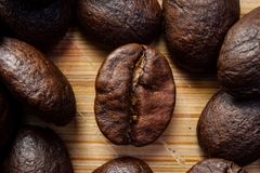 Macro shot showcasing roasted coffee beans on wooden surface for a rich, aromatic appeal.