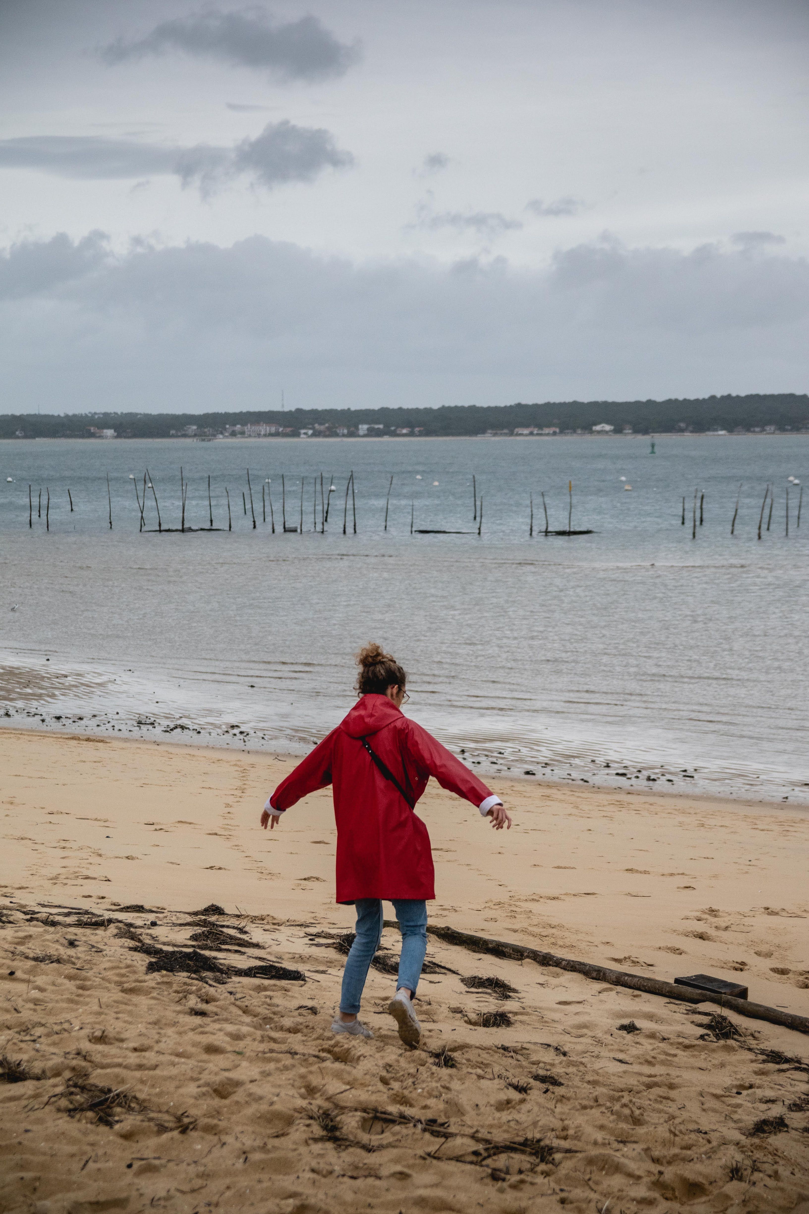 Woman Wearing Red Coat Walking on Beach · Free Stock Photo