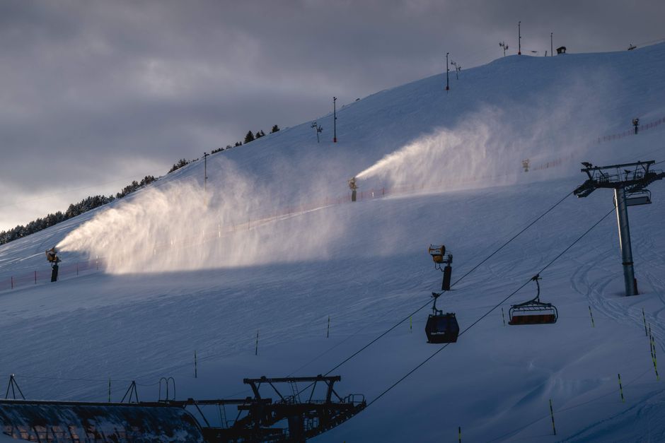 Snow cannons working on ski slope in Huez, France during winter.