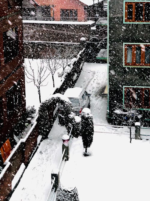 From above of yard of modern residential complex covered with snow on winter day