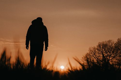 Free A silhouetted figure stands against a stunning sunset in Hagen, Germany. Stock Photo