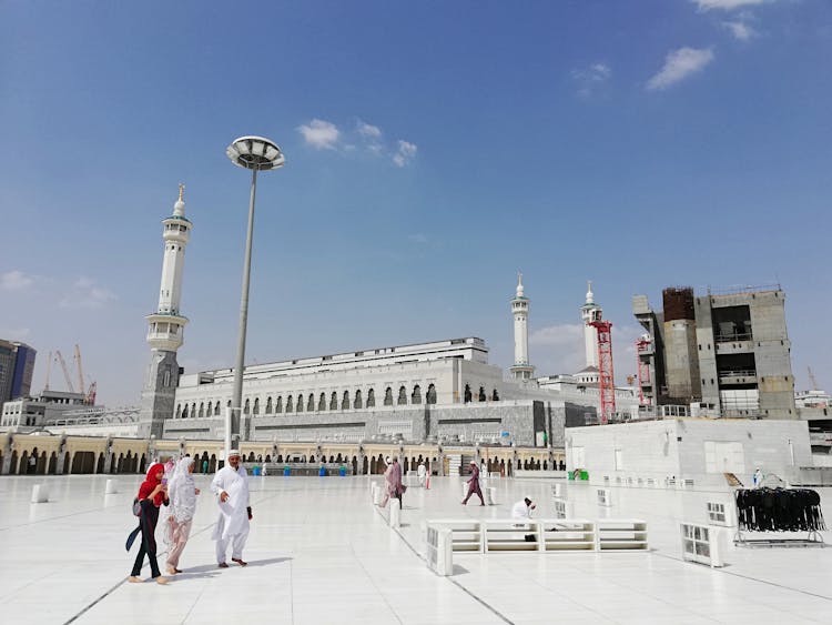 Unrecognizable Muslim Pilgrims Near Ancient Mosque On Sunny Day