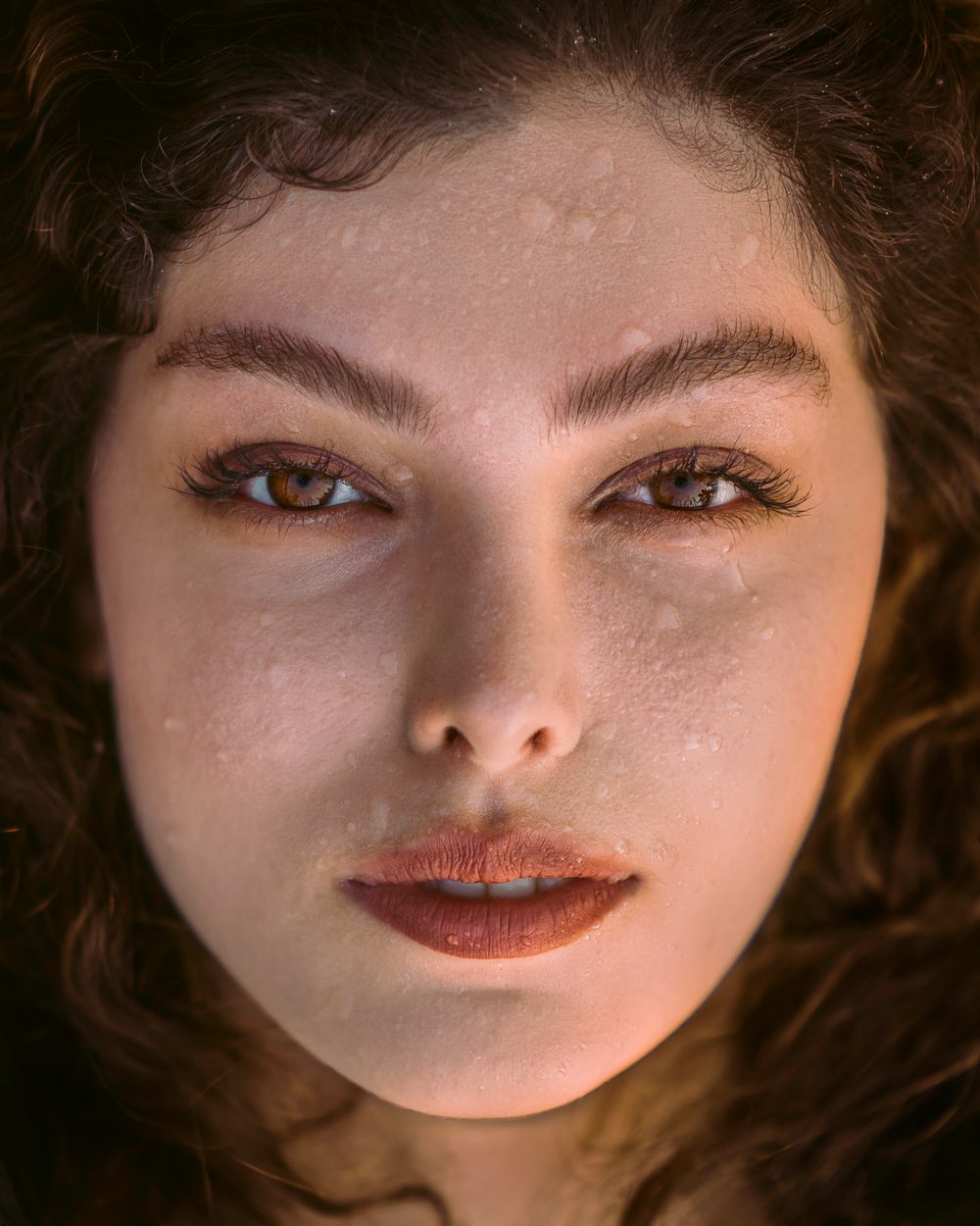 A woman with water droplets on fresh, hydrated-looking skin