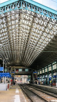 Detailed view of a modern railway station platform with intricate roof design.