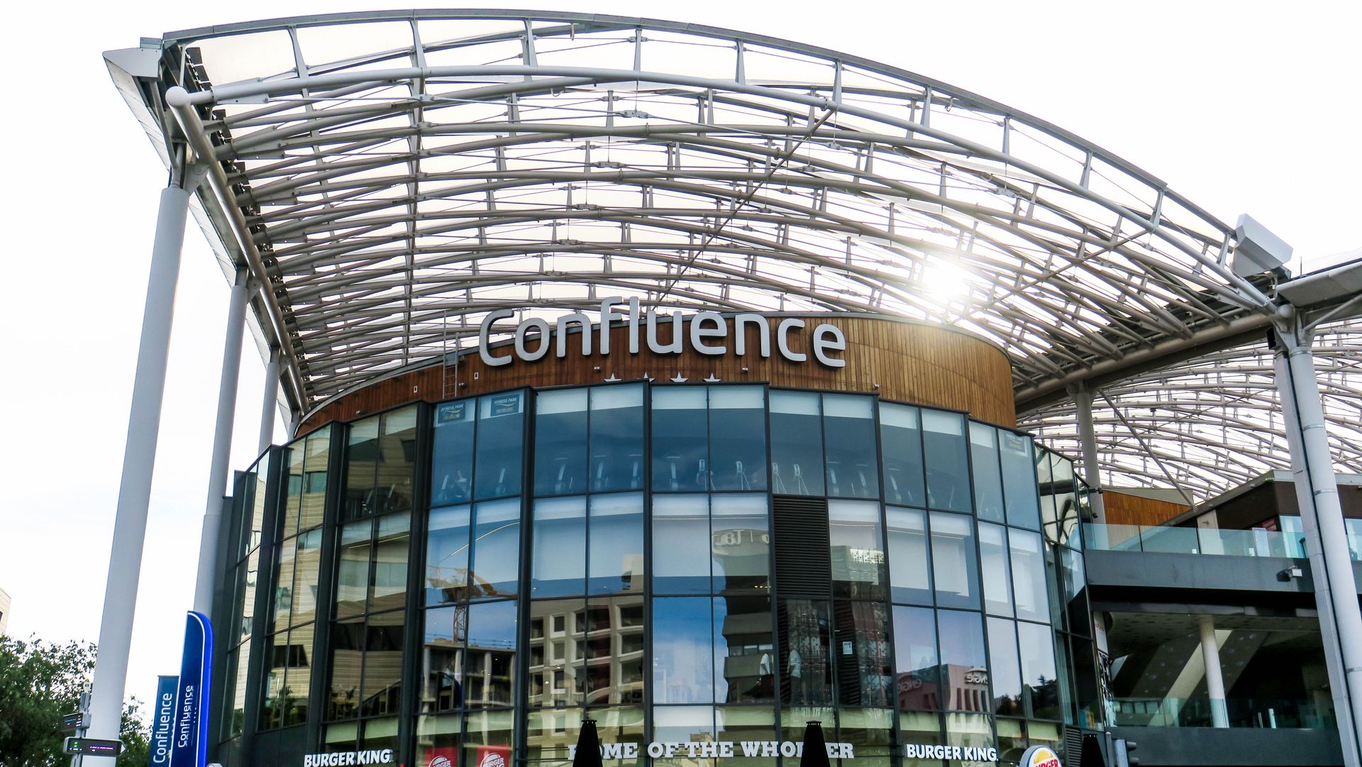 Contemporary design of Confluence shopping center in Lyon with glass facade and steel structures.