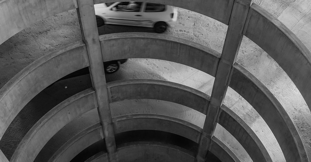 Grayscale Photo of a Car on a Spiral Ramp on Multi Level Parking Area ...
