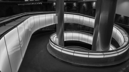 Free Black and white image of a modern spiral staircase with sleek illuminated walls. Stock Photo