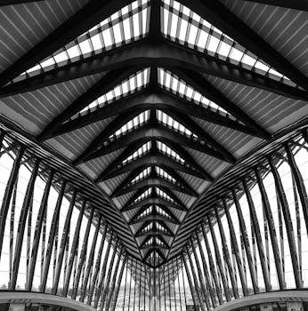 Low angle shot of the geometric steel and glass ceiling at Lyon-Saint Exupery Airport.