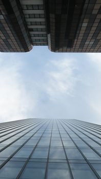 Low-angle shot of modern skyscrapers against a blue sky, highlighting architectural design.