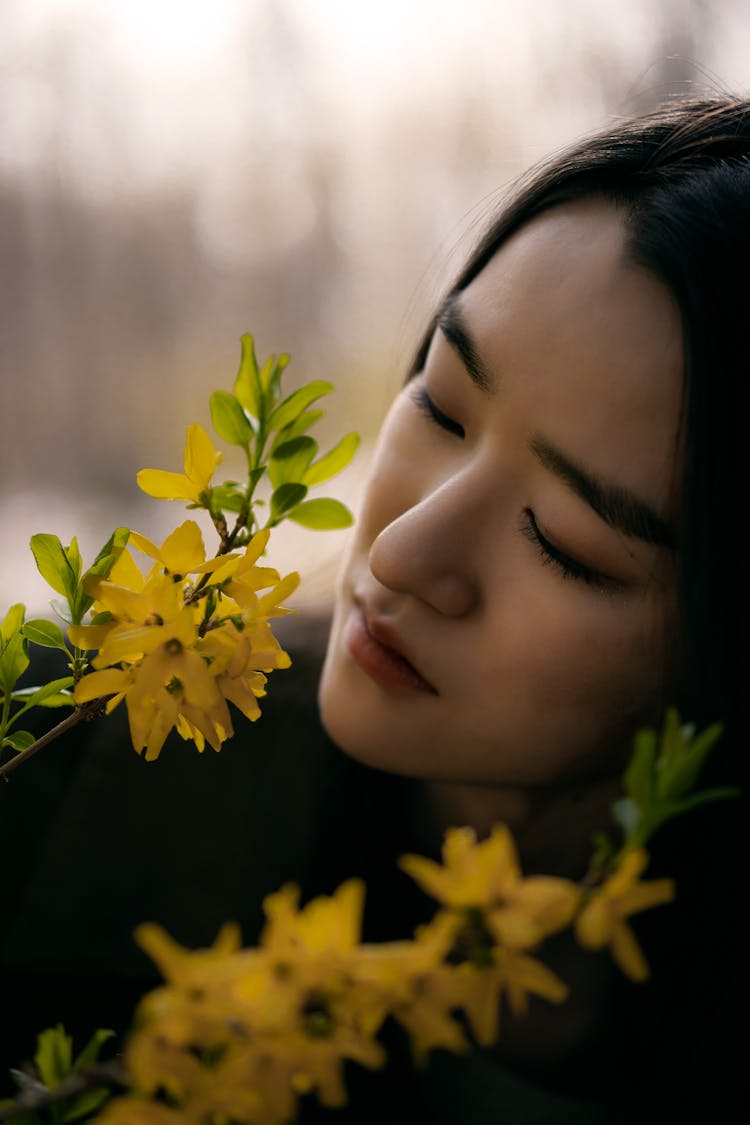 Woman Smelling Yellow Flowers