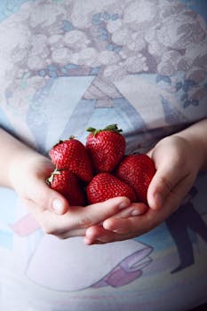 Handful of ripe strawberries in human hands, symbolizing health and freshness.
