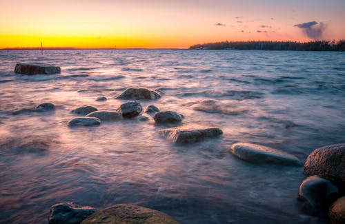 Rocky Shore With Sea Waves Crashing on Shore during Sunset