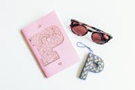 Black Framed Sunglasses Beside Pink Notebook and Letter P Decor