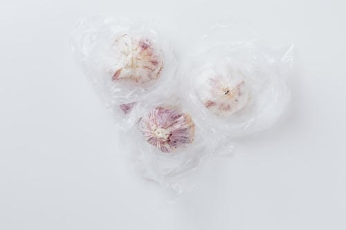 Free Three Garlic Bulbs Inside Clear Plastic Bag Stock Photo