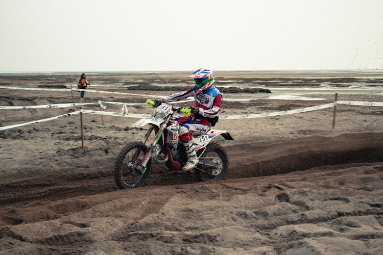 Man Riding Motocross Dirt Bike On Brown Sand