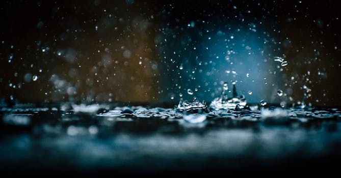 Close-up of raindrops splashing on a surface, captured in a dark, moody setting.