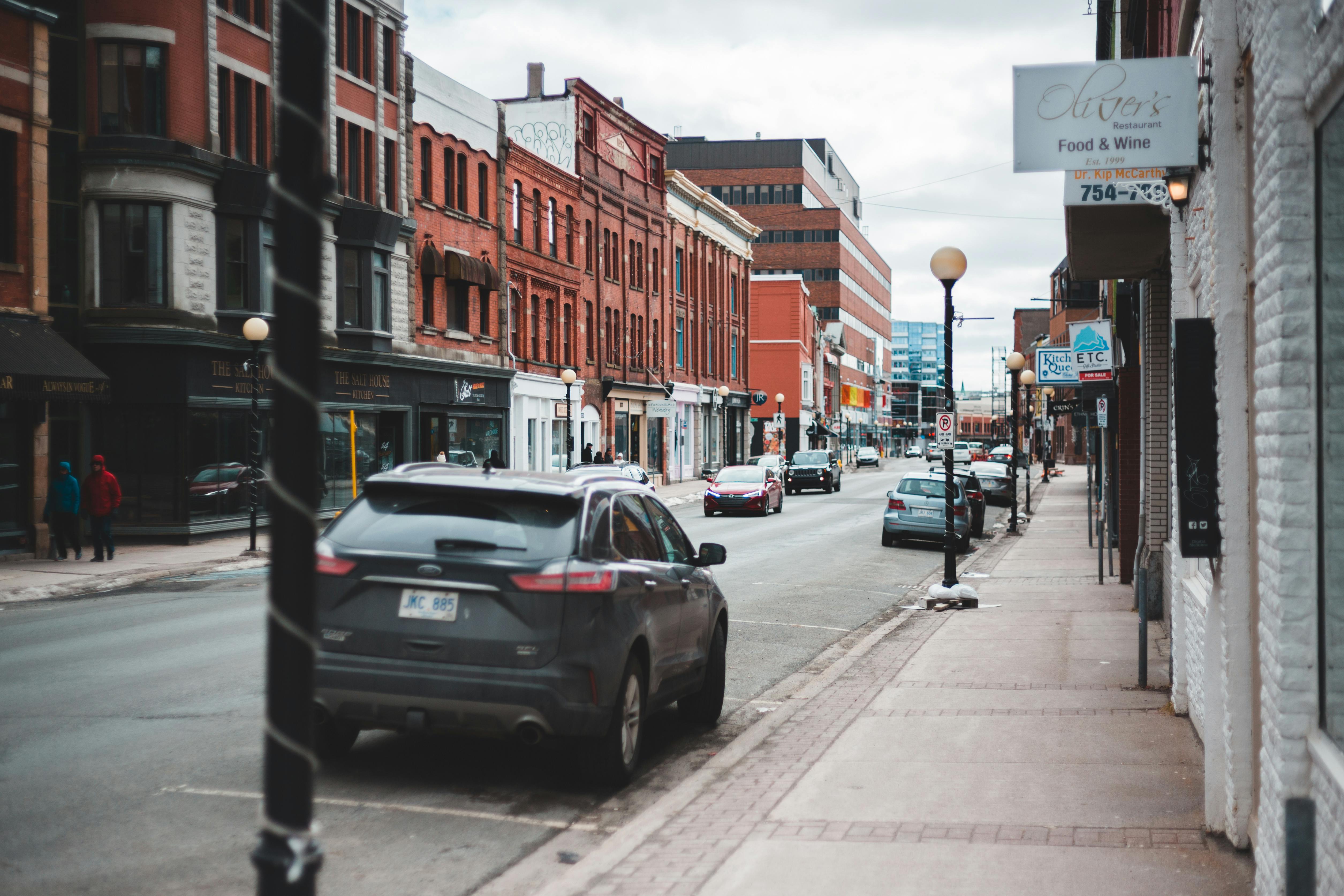 Cars Parked On Sidewalk Near Buildings · Free Stock Photo